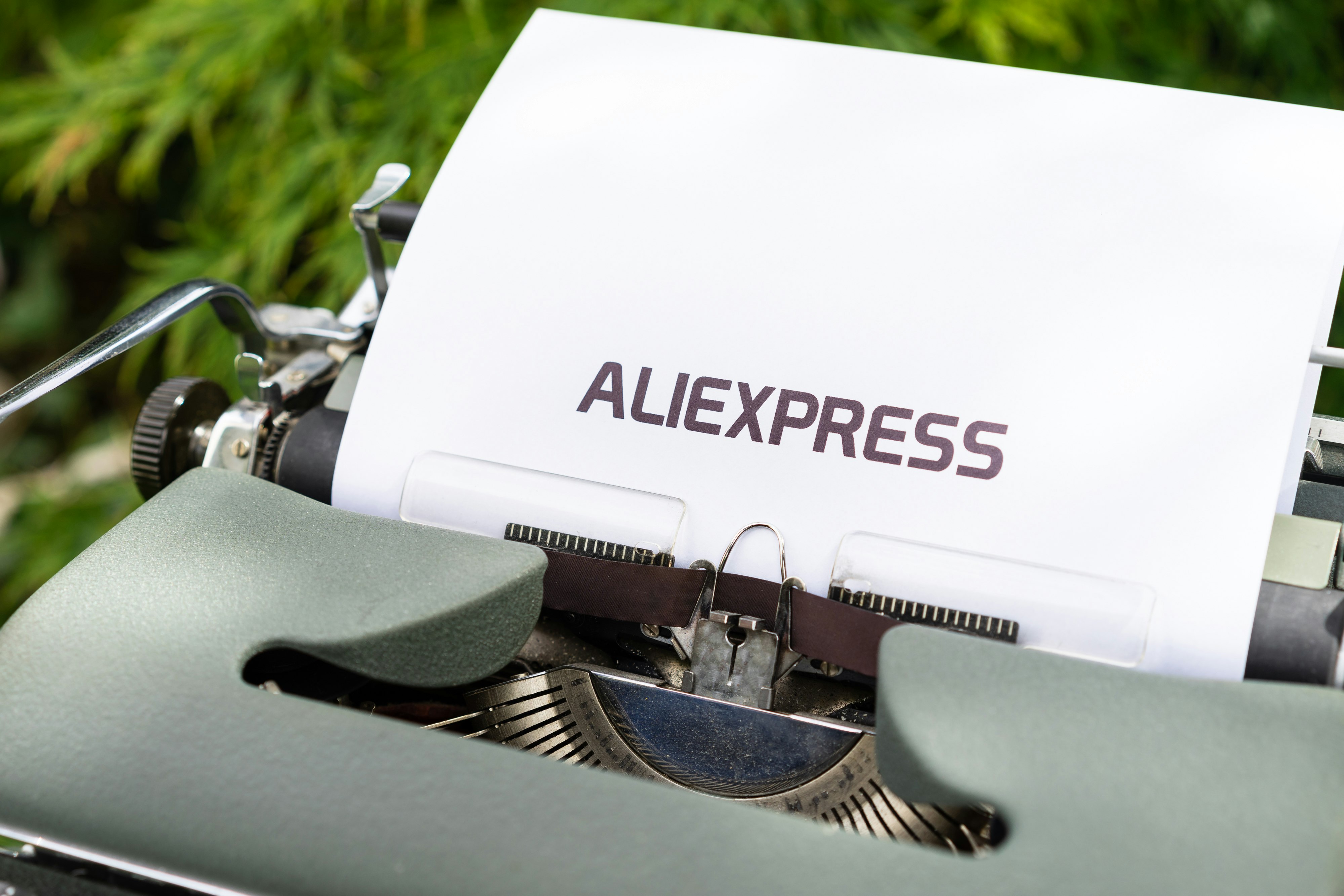 white and black typewriter on green grass during daytime